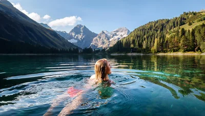 Woman Swimming In A Crystal Clear Alpine Lake