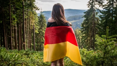 Woman Standing In Forest Wrapped In German Flag