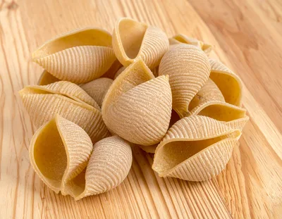 Raw Conchiglioni Pasta Shells on Wooden Surface