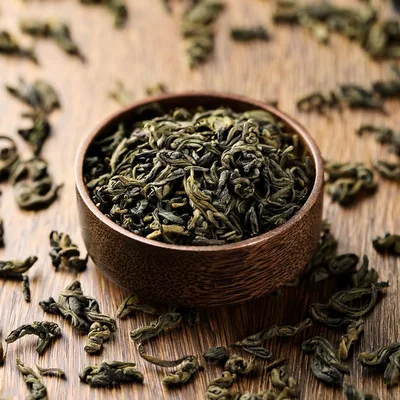 Dried Green Tea Leaves In A Wooden Bowl