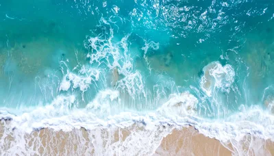 Aerial View Of Turquoise Ocean Waves Crashing On Beach