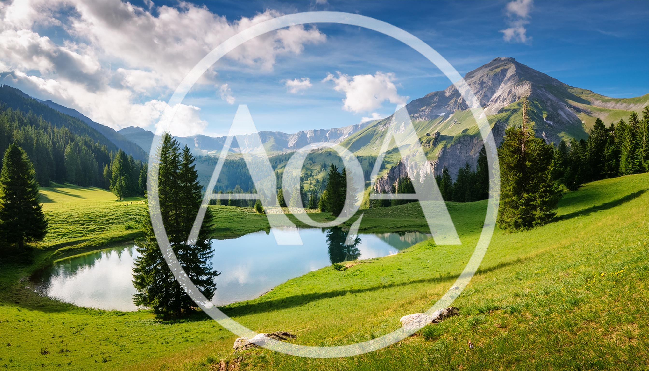 Alpine Lake Surrounded By Lush Green Meadows And Mountains