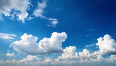 Fluffy White Cumulus Clouds In A Bright Blue Sky