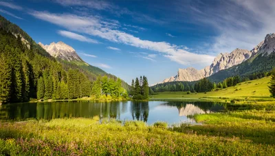 Scenic Alpine Lake Surrounded By Mountains And Wildflower Meadows