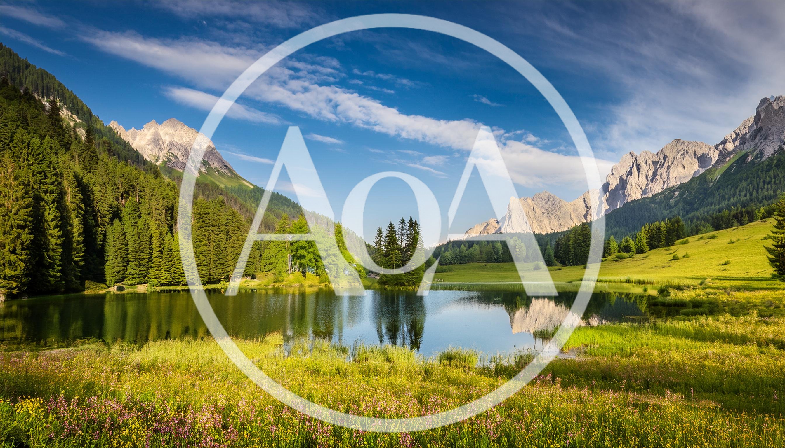 Scenic Alpine Lake Surrounded By Mountains And Wildflower Meadows