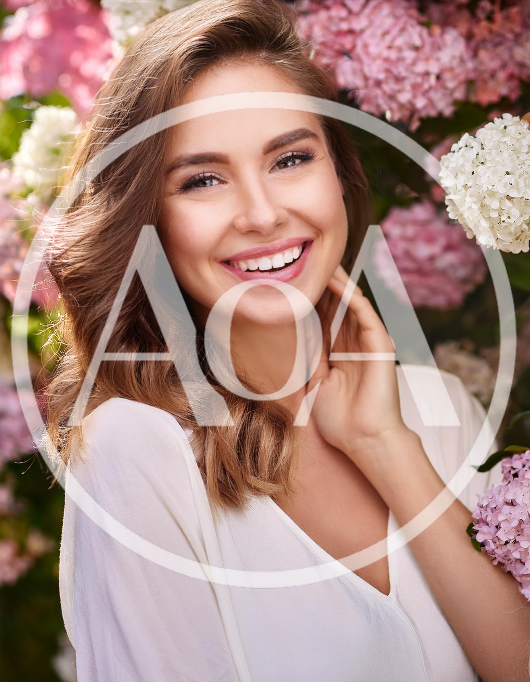 Smiling Woman Posing Amidst Blooming Hydrangea Flowers