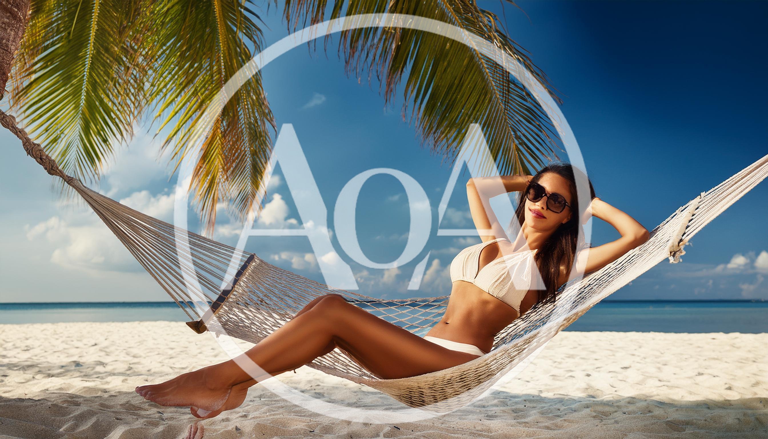 Woman Relaxing In A Hammock On A Tropical Beach
