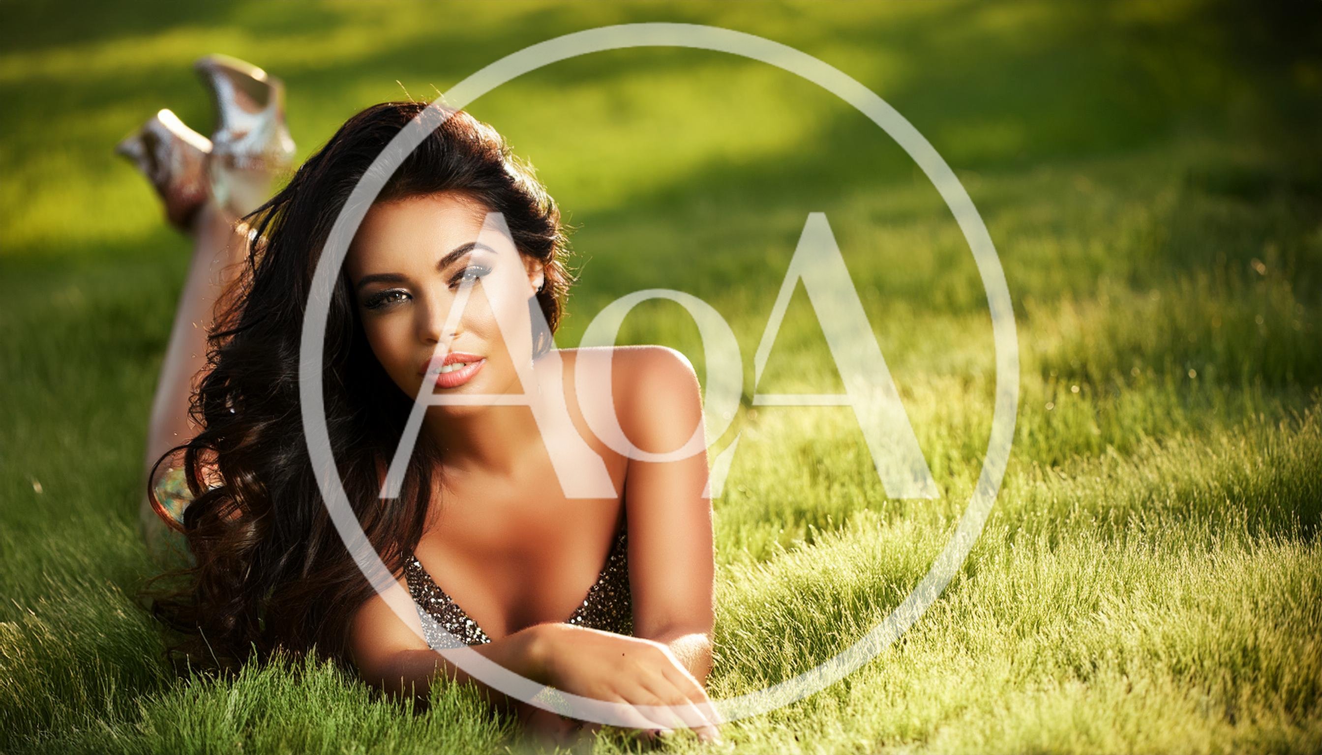 Beautiful Woman Lying On Green Grass In Sunlight