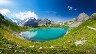 Turquoise Alpine Lake Surrounded By Lush Green Mountains