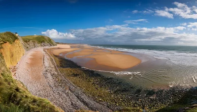 Panoramic View Of A Sandy Beach And Coastal Cliffs