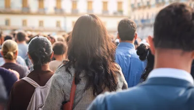 Crowd Of People Walking Through A Sunny City Square