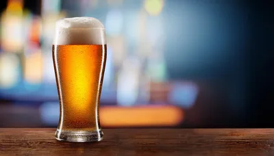 Cold Glass Of Beer On A Wooden Bar Counter
