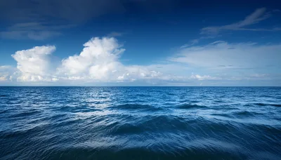 Calm Blue Ocean Waves Under A Cloudy Sky