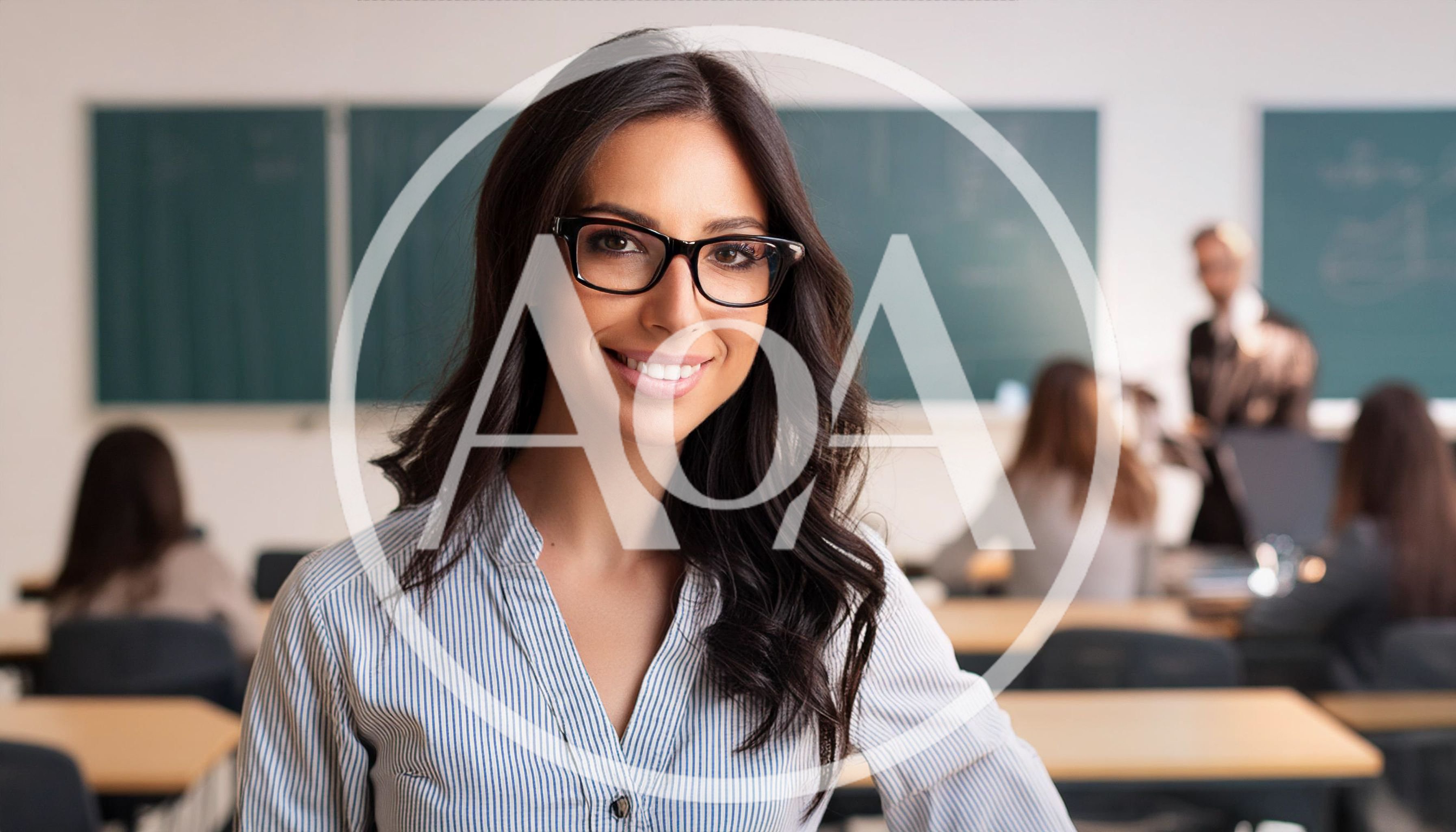 Smiling Female Teacher Standing In A Classroom