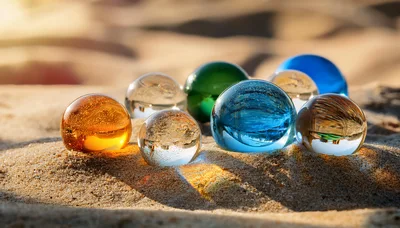 Colorful Glass Spheres Resting On Sandy Beach