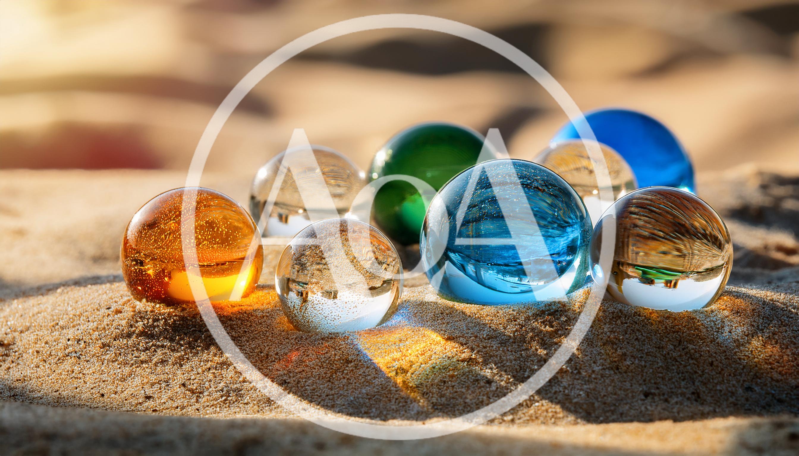 Colorful Glass Spheres Resting On Sandy Beach