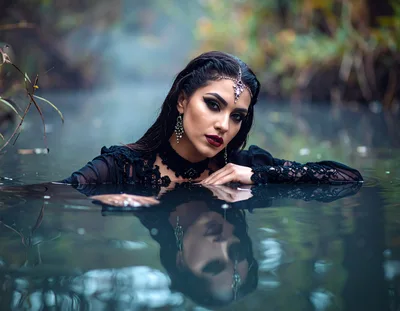 Mysterious Woman In Black Dress Posing In Water