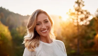 Smiling Woman Standing Outdoors During Golden Hour