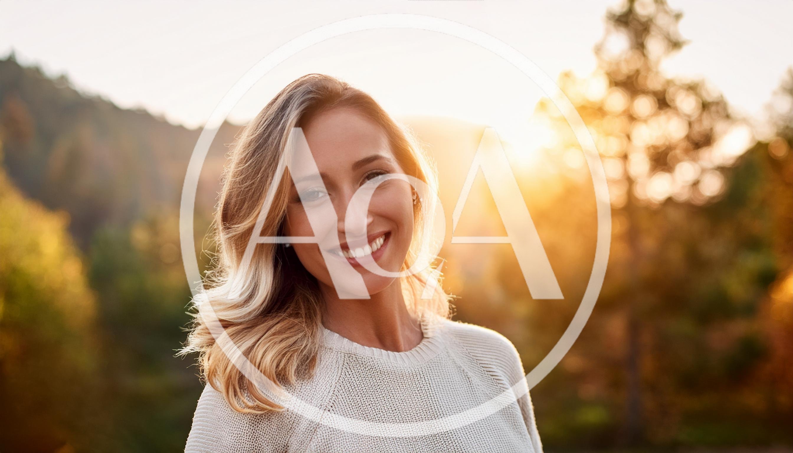 Smiling Woman Standing Outdoors During Golden Hour