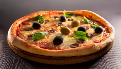 Freshly Baked Pizza With Olives And Basil Leaves