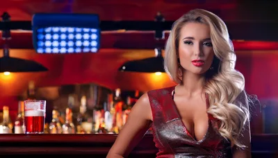 Beautiful Blonde Woman Sitting At A Bar Counter