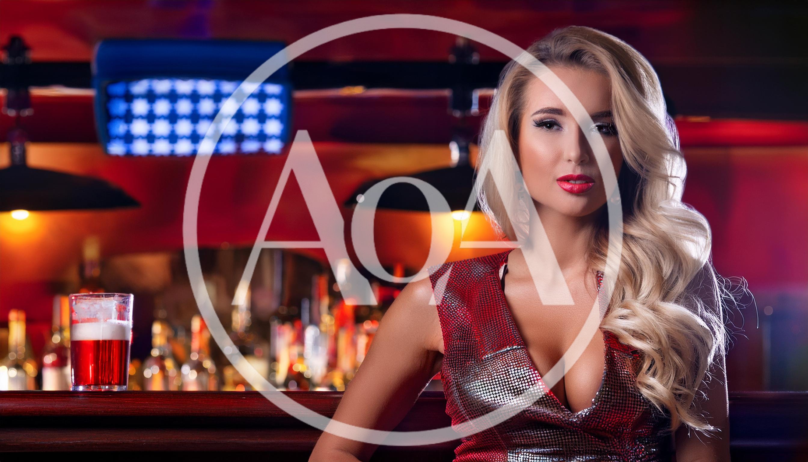 Beautiful Blonde Woman Sitting At A Bar Counter