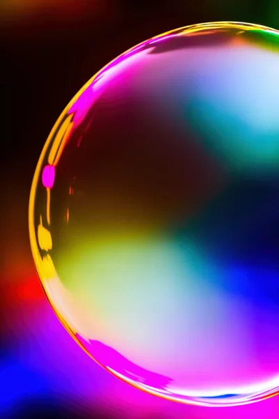 Iridescent Soap Bubble Floating Against A Colorful Abstract Background