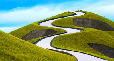 Winding Road Through Vibrant Green Rolling Hills