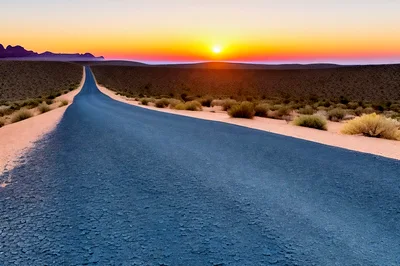 Empty Asphalt Road Through Desert Landscape At Sunset