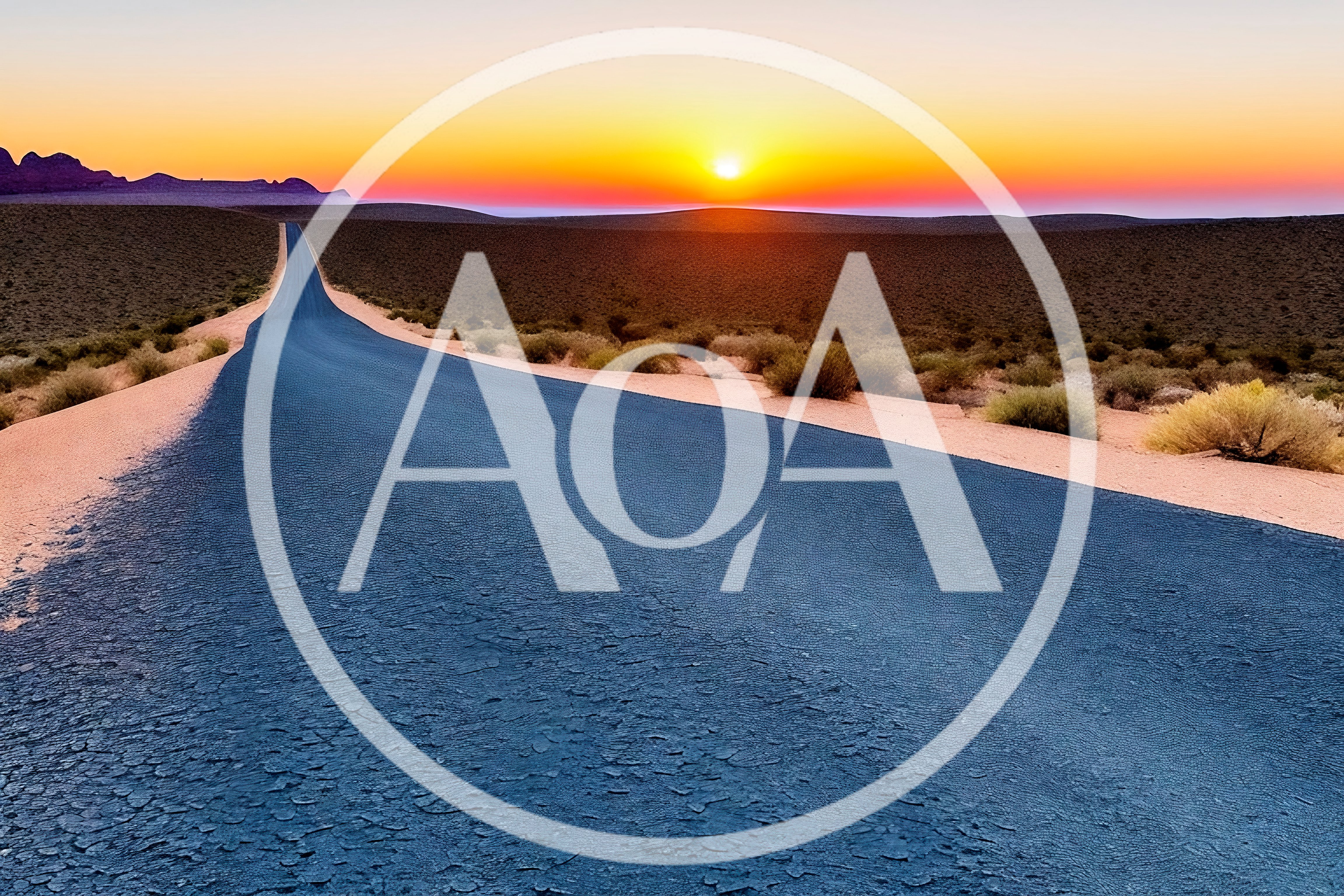 Empty Asphalt Road Through Desert Landscape At Sunset