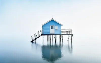 Blue Stilt House Standing Above Calm Water