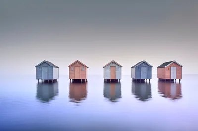 Five Colorful Beach Huts Standing Over Calm Water