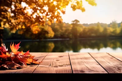 Autumn Leaves On A Wooden Table By A Lake