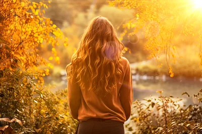 Woman With Long Wavy Hair Standing In Autumn Forest