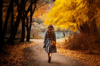 Woman Walking Along A Path In Autumn Park